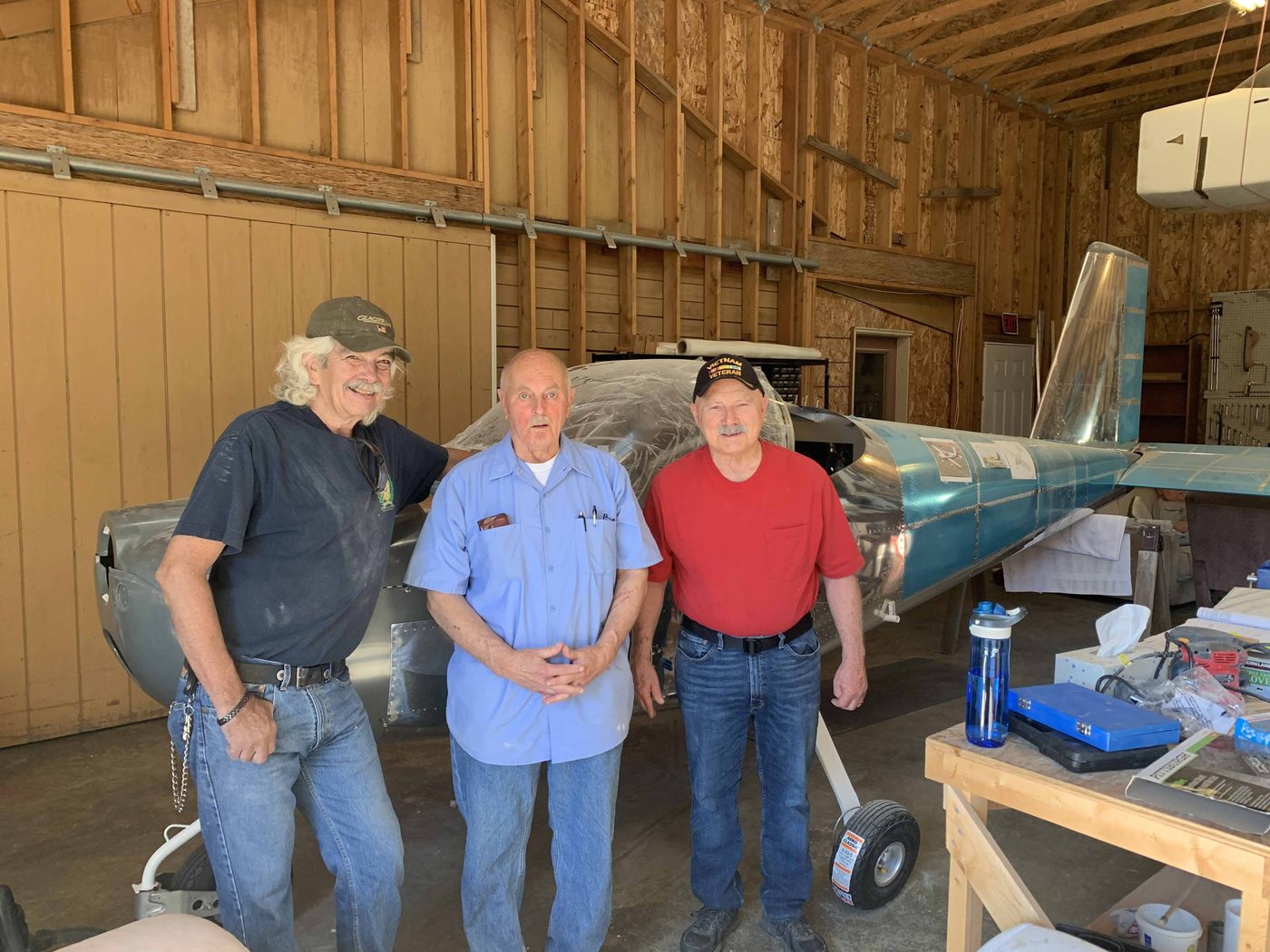 Silver Eagle members standing beside the aircraft build in the workshop