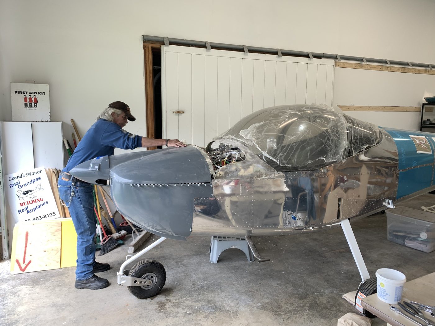 A member working on the silver aircraft in the workshop